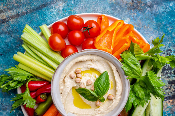 Hummus platter with assorted snacks. Hummus platter with assorted snacks. Hummus in bowl and vegetables sticks. Plate with Middle Eastern. Party, finger food. Top view. Vegan, hummus dip cracker snack photos stock pictures, royalty-free photos & images