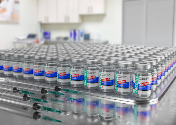 Hundreds of Coronavirus COVID-19 Vaccine Booster Vials and Syringes In Medical Office. stock photo