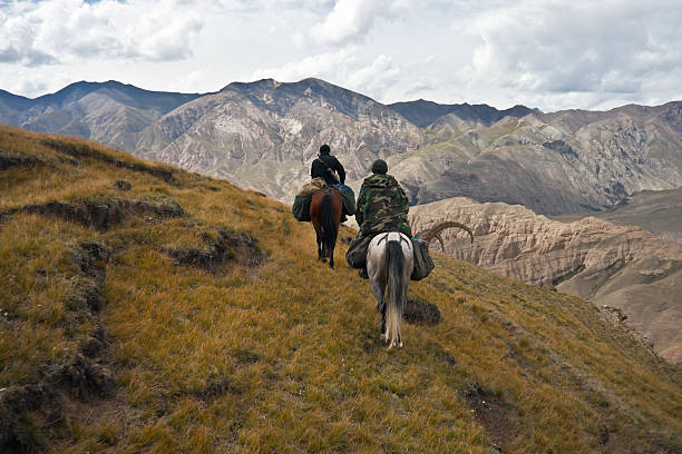 Hunters two horses returned with a trophy after a hunt Hunters two horses returned with a trophy after a hunt in the mountains of Tien Shan, Kyrgyzstan, tien shan mountains stock pictures, royalty-free photos & images