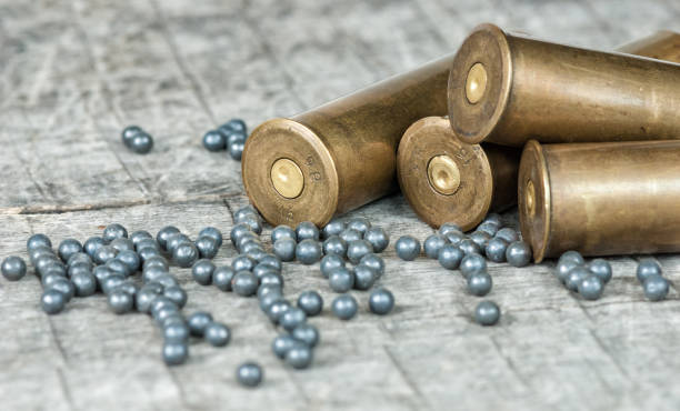Hunting cartridges and lead shot Hunting cartridges and lead shot are on a wooden background ammunition stock pictures, royalty-free photos & images