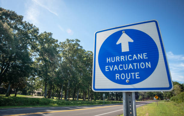 Hurricane Evacuation Route Sign A sign directs hurricane evacuees to safety. evacuation stock pictures, royalty-free photos & images