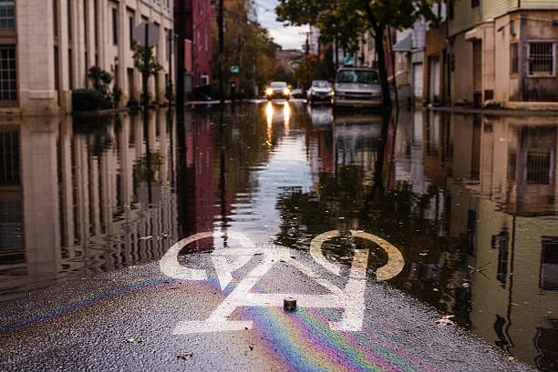 Hurricane Sandy: road sign submerged on a flooded street "Hoboken, New Jersey, USA - October 31, 2012: Flooded street with submerged road sign in the foreground after Hurricane Sandy landfall" new jersey street flooding stock pictures, royalty-free photos & images