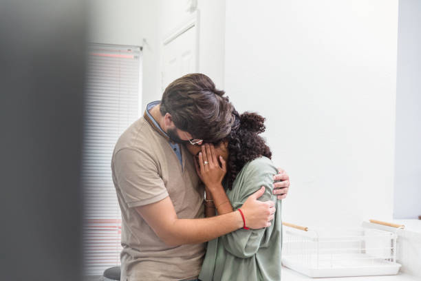 de echtgenoot troost huilende vrouw met migraine - embrace man woman serious stockfoto's en -beelden