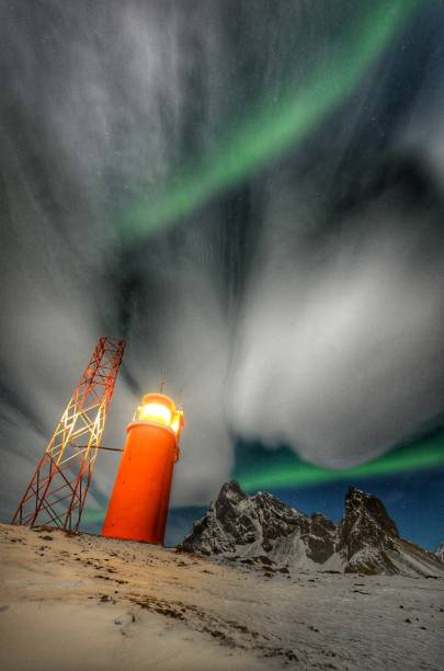 hvalnes Lighthouse during aurora borealis iceland stock photo