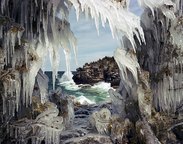 Ice Cave Winter landscape of waves crashing against a cliff on the Bruce Peninsula. bruce peninsula national park stock pictures, royalty-free photos & images