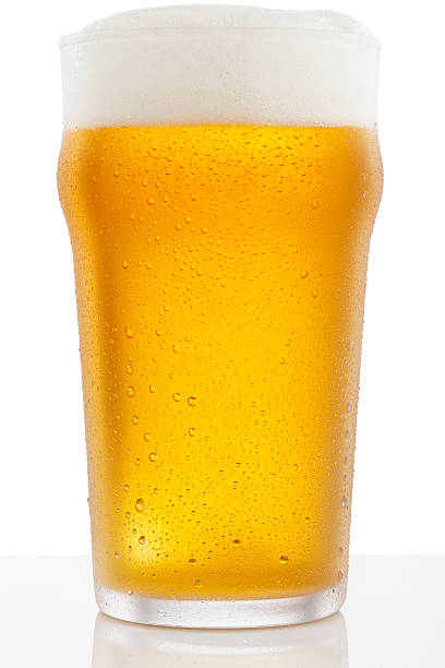 Ice Cold  Glass of  Beer  Covered with water drops  condensation Ice Cold  Glass of  Beer , covered with water drops - condensation. Standing on white  counter at a bar. Foam on the beer looks real and perfect.  Isolated On White, plain background -  Clipping Path. pint glass stock pictures, royalty-free photos & images