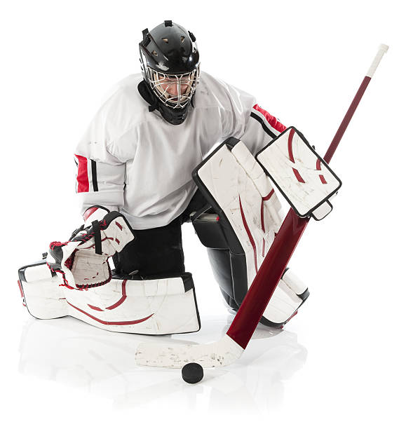 Ice hockey goalie kneeling on the field holding the stick stock photo