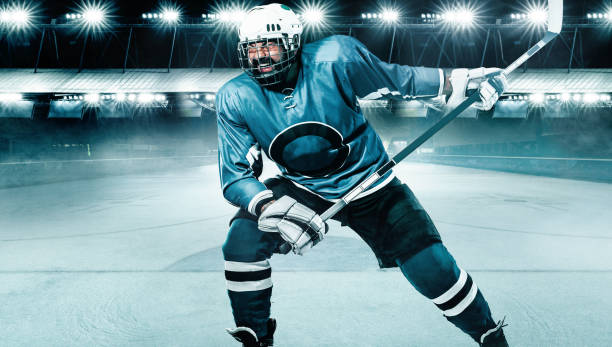 Ice Hockey player athlete in the helmet and gloves on stadium with stick. Action shot. Sport concept. Hockey player in the mask on stadium. hockey goalie stick stock pictures, royalty-free photos & images