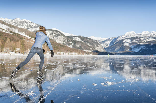 Ice Skating, Frozen Lake Grundlsee, Austria Beautiful woman ice skating on the frozen lake Grundlsee in front of a stunning Alps panorama. Nikon 810. Converted from RAW. ausseerland stock pictures, royalty-free photos & images