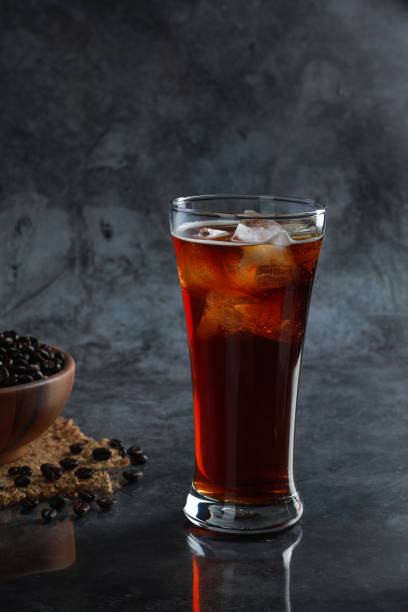 Iced Americano coffee in the glass with coffee beans in background. Diet drink or no sugar concept. stock photo