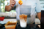 Iced Caramel Macchiato - A glass of espresso mixed with vanilla syrup, milk and ice, topping with caramel syrup, Refreshing homemade summer drink concept.