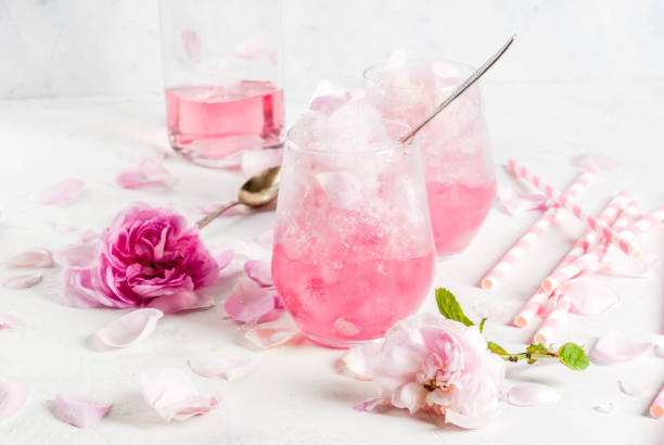 Iced summer dessert Frose Summer refreshing desserts. Vegan diet food. Ice cream frozen rose, froze, with rose petals and rose wine. On a white concrete table, with spoons, striped straws, petals and rose flowers. Copy space frozen rose stock pictures, royalty-free photos & images