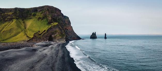 Rynisfjara Black Sand Lava Beach Panorama. Drone Point of view to the famous Reynisdrangar Basalt Sea Stack Cliffs in the North Atlantic Ocean along Rynisfjara Black Sand Lava Beach, close to Vik i Myrdal, the southernmost tip of Iceland. Stacked XXXL Panorama. Rynisfjara, Vik i Myrdal, South Central Iceland, Iceland, Nordic Countries, Europe