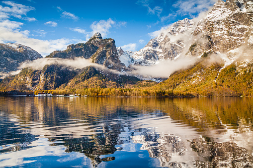 Idyllic autumn scene in the Alps with mountain lake reflection in beautiful morning light.