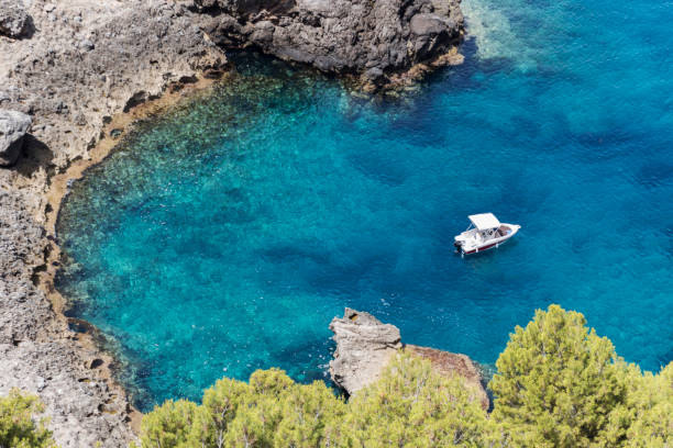 Idyllic Mediterranean Lagoon Small Boat in a Beautiful Turquoise Mediterranean erik trampe stock pictures, royalty-free photos & images