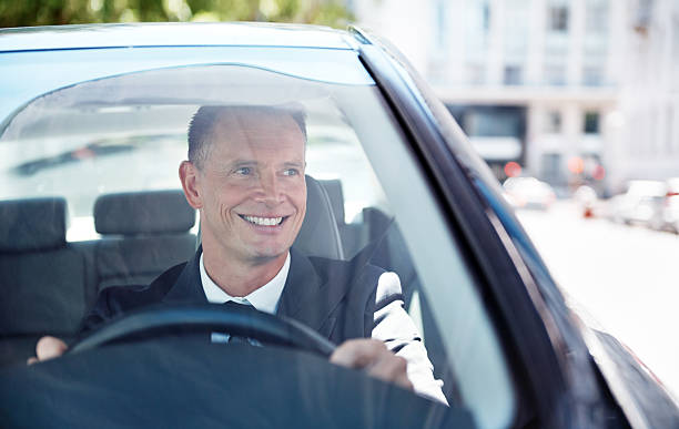 If you can dream it, you can achieve it Shot of a handsome businessman driving his car man driving suit stock pictures, royalty-free photos & images