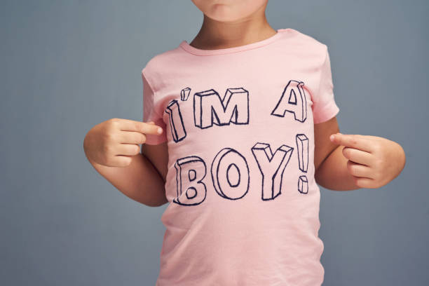 If you have to ask... Studio shot of a boy wearing a t shirt with “I’m a boy” printed on it against a gray background gender stereotypes stock pictures, royalty-free photos & images