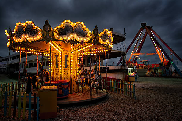 Illuminated carousel in an empty carnival Carousel In Yalova Fun Fair, Turkey carousel horses stock pictures, royalty-free photos & images