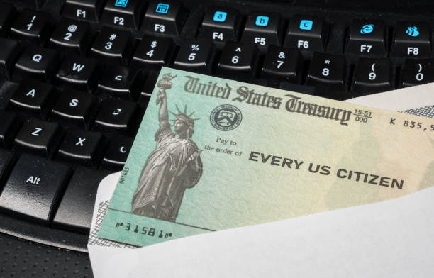 Illustration of the federal stimulus payment check from the IRS on keyboard US Treasury concept check to illustrate coronavirus stimulus payment on keyboard used for working from home economic stimulus stock pictures, royalty-free photos & images