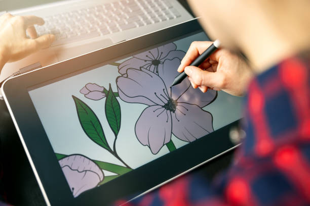 illustrator graphic designer draw flower illustration on drawing tablet. digital artist at work stock photo
