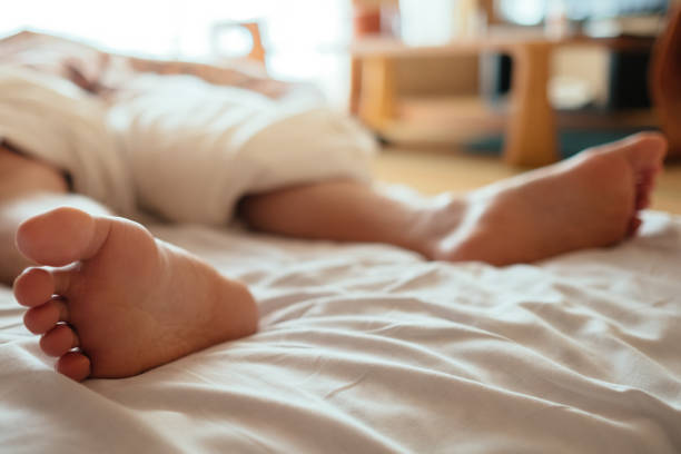 Image of a man's leg protruding from traditional Japanese bedding stock photo