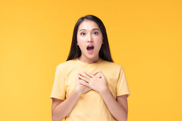 Image of feeling excited, shock, surprise and happy. Young asian woman standing on yellow background. Female face expressions and emotions body language concept. Image of feeling excited, shock, surprise and happy. Young asian woman standing on yellow background. Female face expressions and emotions body language concept. cute thai girl stock pictures, royalty-free photos & images