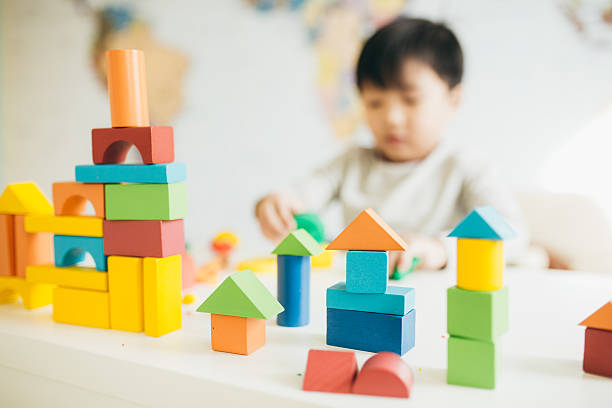 Importance of play in child development Focus on  wooden blocks and child on background autisticerapy stock pictures, royalty-free photos & images
