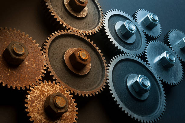 Improving Economy Rusty and Shinny Gears Working Together. rusty stock pictures, royalty-free photos & images