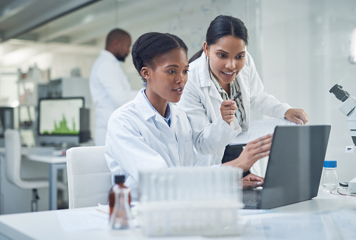 Shot of two young scientists using a laptop in a laboratory