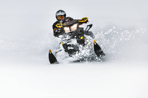 In deep snowdrift snowmobile rider make fast turn stock photo