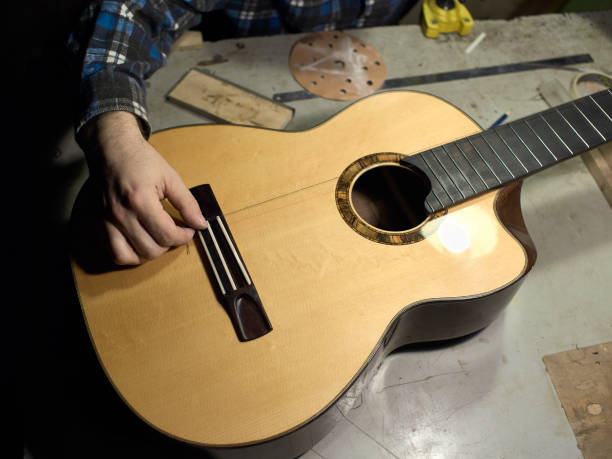 In the guitar workshop, Guitars Luthiers checks the accuracy of the neck and saddle setting. stock photo