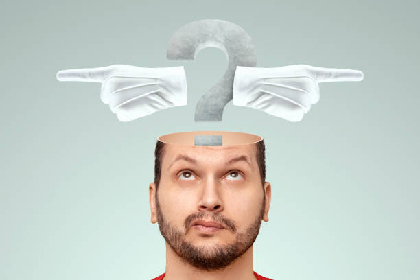 In the man's head there is a question mark and index fingers in different directions. The concept of the problem of choice, a difficult decision, to be or not to be, the choice of the path. stock photo