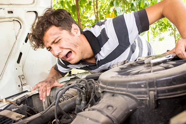 Incompetent repairman crying next to car stock photo