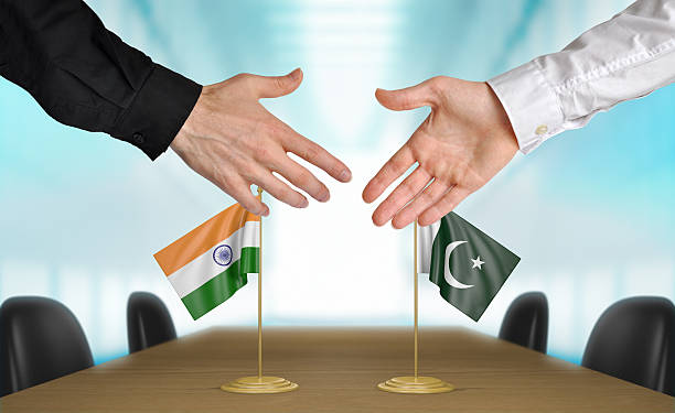 India and Pakistan diplomats shaking hands to agree deal Two diplomats from India and Pakistan extending their hands for a handshake on an agreement between the countries. pakistani flag stock pictures, royalty-free photos & images