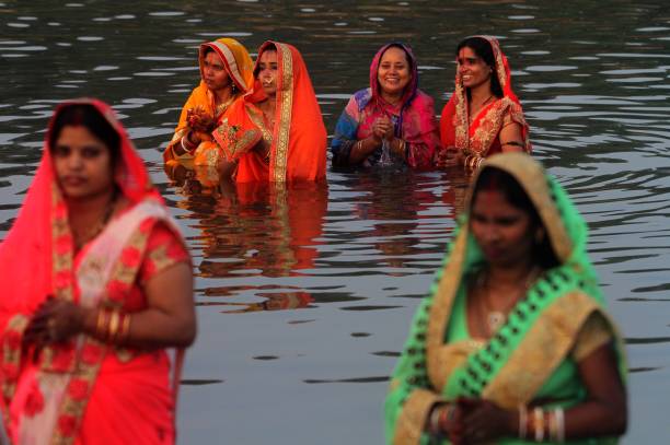 India Hindu Festival Indian Bihari community women are seen in the water of River Kuakhai as they offer rituals to the Sun God on the occasion of Indian Hindu festival "Chhhath Puja" outskirts of the eastern Indian state Odisha's capital city Bhubaneswar. Chhath Puja two days rituals celebrates in the water bodies on the Sun set and rising time by senior woman and man of Bihari cummunity in India. chhath stock pictures, royalty-free photos & images