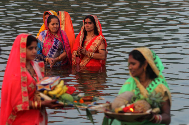 India Hindu Festival Indian Bihari community women are seen in the water of River Kuakhai as they offer rituals to the Sun God on the occasion of Indian Hindu festival "Chhhath Puja" outskirts of the eastern Indian state Odisha's capital city Bhubaneswar. Chhath Puja two days rituals celebrates in the water bodies on the Sun set and rising time by senior woman and man of Bihari cummunity in India. chhath stock pictures, royalty-free photos & images