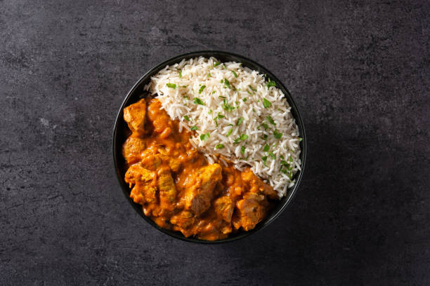 Indian butter chicken in black bowl stock photo