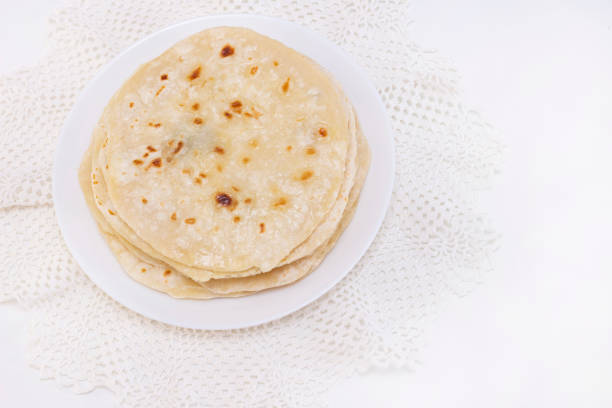 indian chapati bread. chapati on a white plate on a white background. cooking in a dry pan. indian chapati bread. chapati on a white plate on a white background. cooking in a dry pan. chapatti stock pictures, royalty-free photos & images