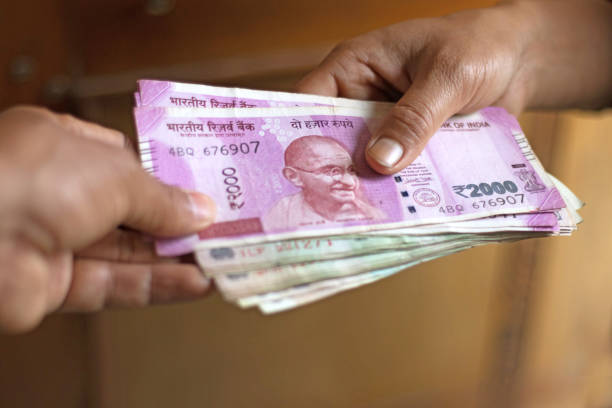 Indian Currency notes getting exchanged between two hands Indian Currency notes getting exchanged between two hands INDIA CURRENCY stock pictures, royalty-free photos & images