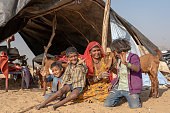 istock Indian family together with a goat outdoors in desert on time Pushkar Camel Mela, Rajasthan, India 1278916479