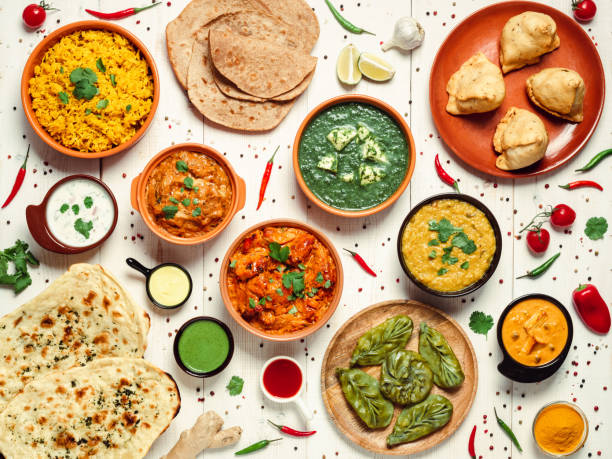 Indian food and indian cuisine dishes, top view Indian cuisine dishes: tikka masala, dal, paneer, samosa, chapati, chutney, spices. Indian food on white wooden background. Assortment indian meal top view or flat lay. chapatti stock pictures, royalty-free photos & images