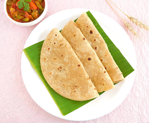 Indian Food Chapati Indian food chapati, or Indian flat bread is made from wheat flour dough and is a traditional and popular cuisine, on a banana leaf. chapatti stock pictures, royalty-free photos & images