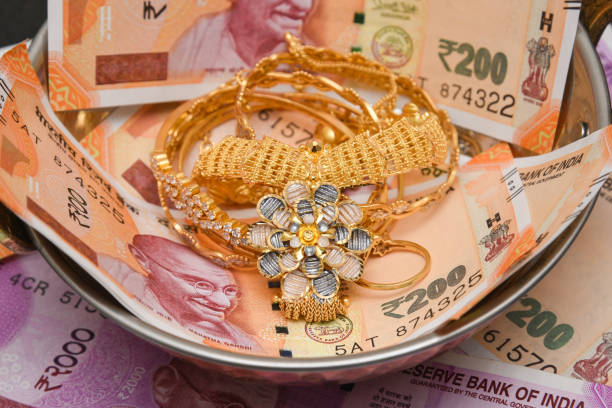 Indian gold jewellery with brand new Indian currency bank notes cash money Gold necklace ornaments expensive and wealthy asset of Indian women. The brand new Indian currency bank notes of 50, 200, 500 and 2000 rupees bundle. Success and got profit from business. GST tax on goods and service. Wealth creation concept. Gold  stock pictures, royalty-free photos & images