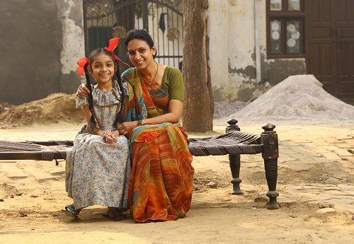 Indian Happy Rural Mother & daughter in village, both looking at camera with smiling faces