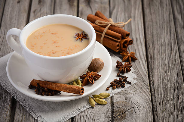 Indian masala chai tea Indian masala chai tea. Spiced tea with milk on the rustic wooden table. Selective focus, copy space. bengali sweets stock pictures, royalty-free photos & images