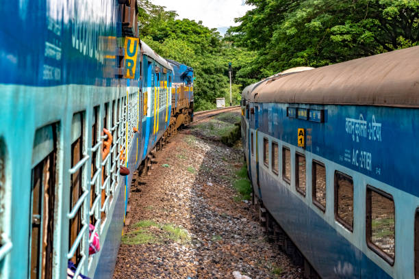 Indian Railways Train departing from station at slow pace, while crossing another train running parallel to it in opposite direction, amidst greenery of Western Ghats. Indian Railways Train departing from station at slow pace, while crossing another train running parallel to it in opposite direction, amidst greenery of Western Ghats. chhath stock pictures, royalty-free photos & images