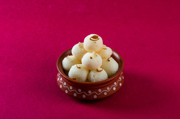 Indian Sweet or Dessert - Rasgulla, Famous Bengali sweet in clay bowl on a pink background. Indian Sweet or Dessert - Rasgulla, Famous Bengali sweet in clay bowl on a pink background. bengali sweets stock pictures, royalty-free photos & images