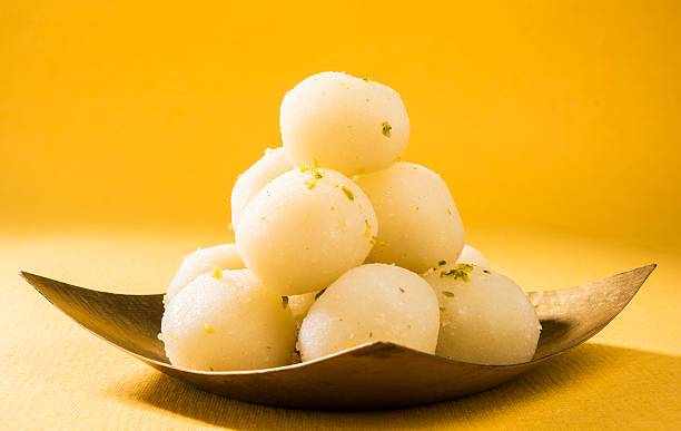 Indian sweet. Rasgulla is a syrupy dessert Indian cottage cheese Bangladesh or india's favourite sweet rasgulla, dry rasgulla, bengal sweets, made of milk / khoya, sweet meets, curved in a steel plate, extreme closeup, front angle bengali sweets stock pictures, royalty-free photos & images