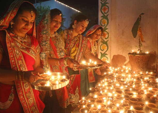 Indian Women Celebrate Diwali In India Indian House Wife wear traditional dress and preparation light oil lamps on the occasion of Diwali Festival (Lighting Festival). Deepawali is certainly one of the biggest, brightest and most important festivals of India. The celebration of Diwali as the 'victory of good over evil' refers to the light of higher knowledge dispelling all ignorance ayodhya stock pictures, royalty-free photos & images