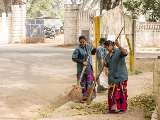 Indian women cleaning road in the street stock photo